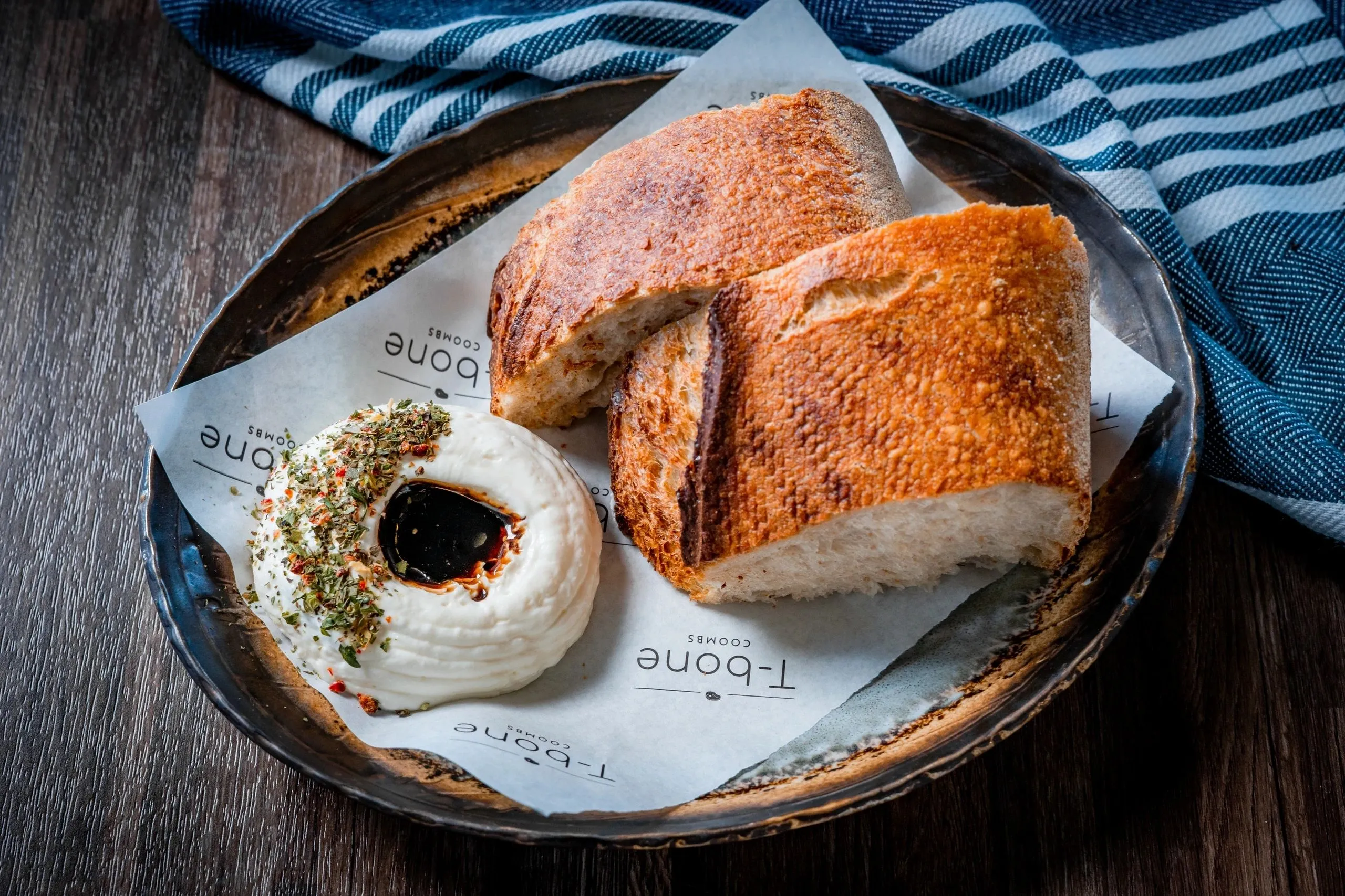 Toasted bread with whipped butter and balsamic on T-bone branded paper