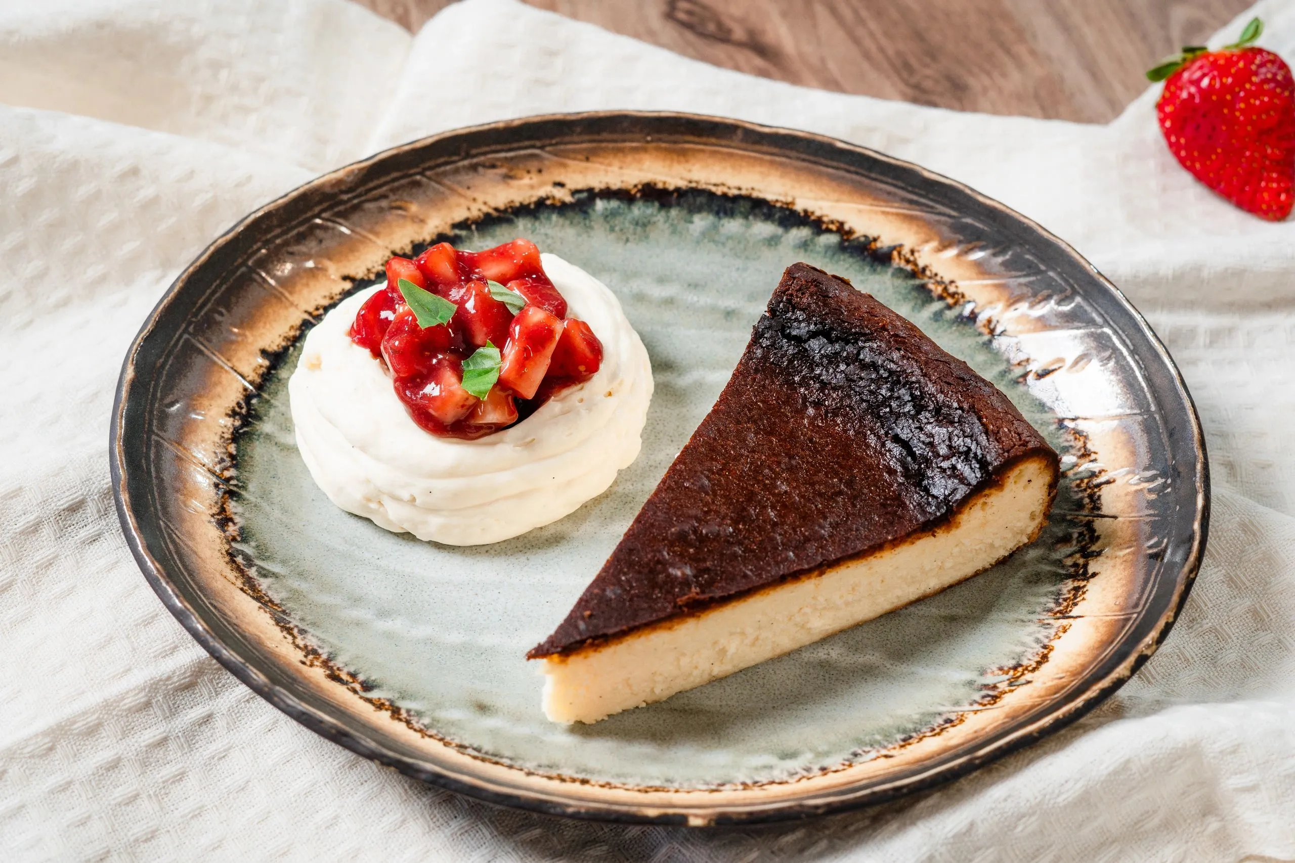 Burnt basque cheesecake with whipped cream and macerated strawberries