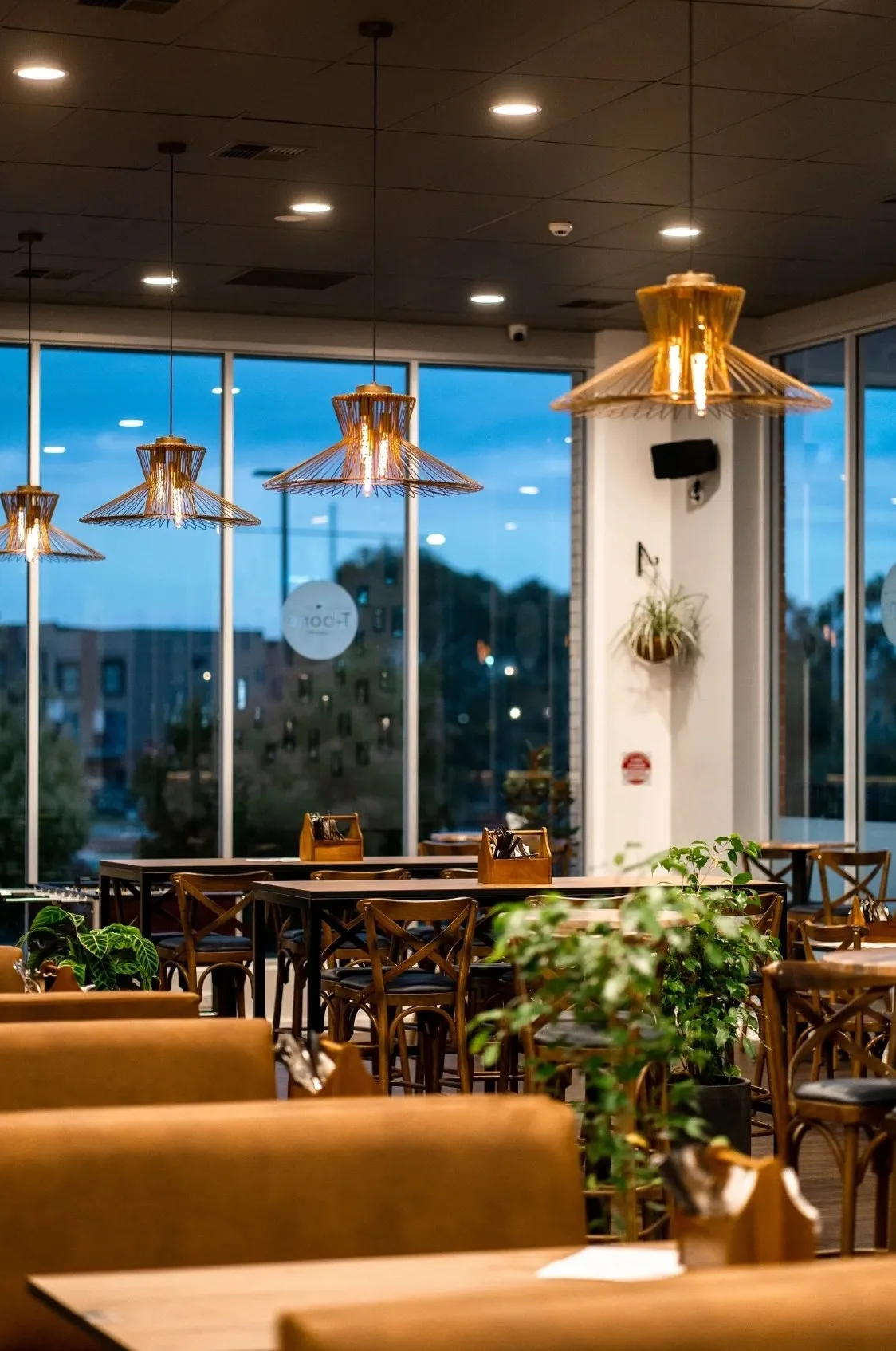 The T-bone dining room at dusk under copper pendant lights