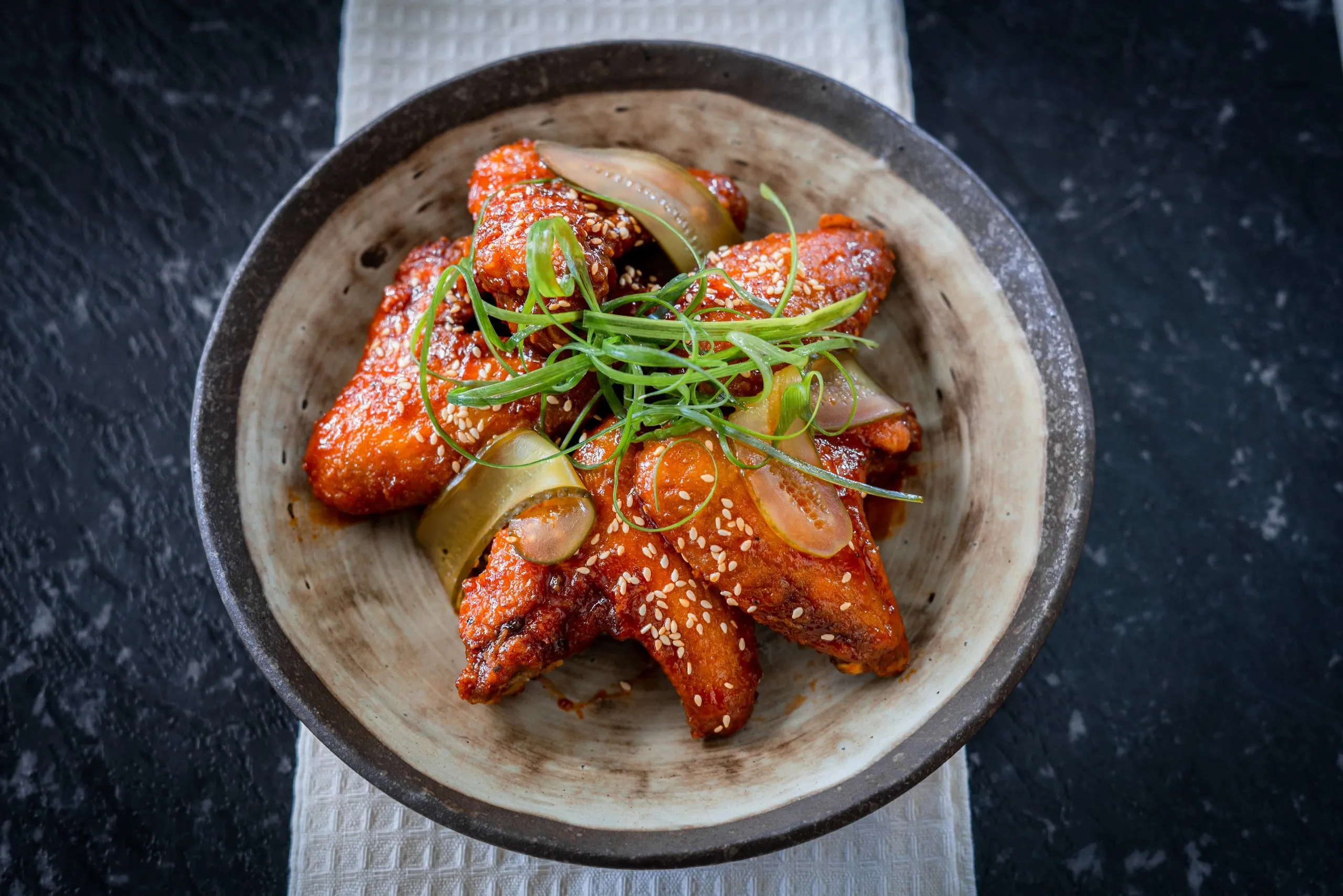 Glazed chicken wings with sesame and spring onion, from above